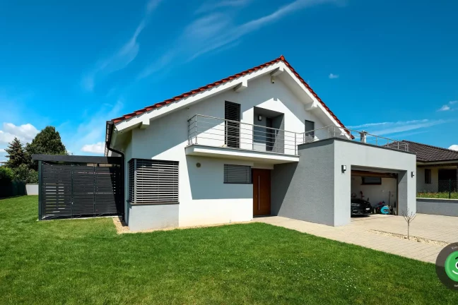 Rodinný dom s garážou s pristavenou čiernou GARDEON pergolou.