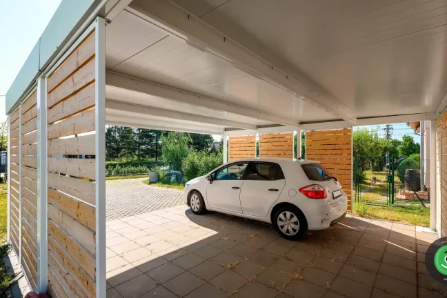 GARDEON prístrešok s bielou strechou a hnedou drevenou výplňou.