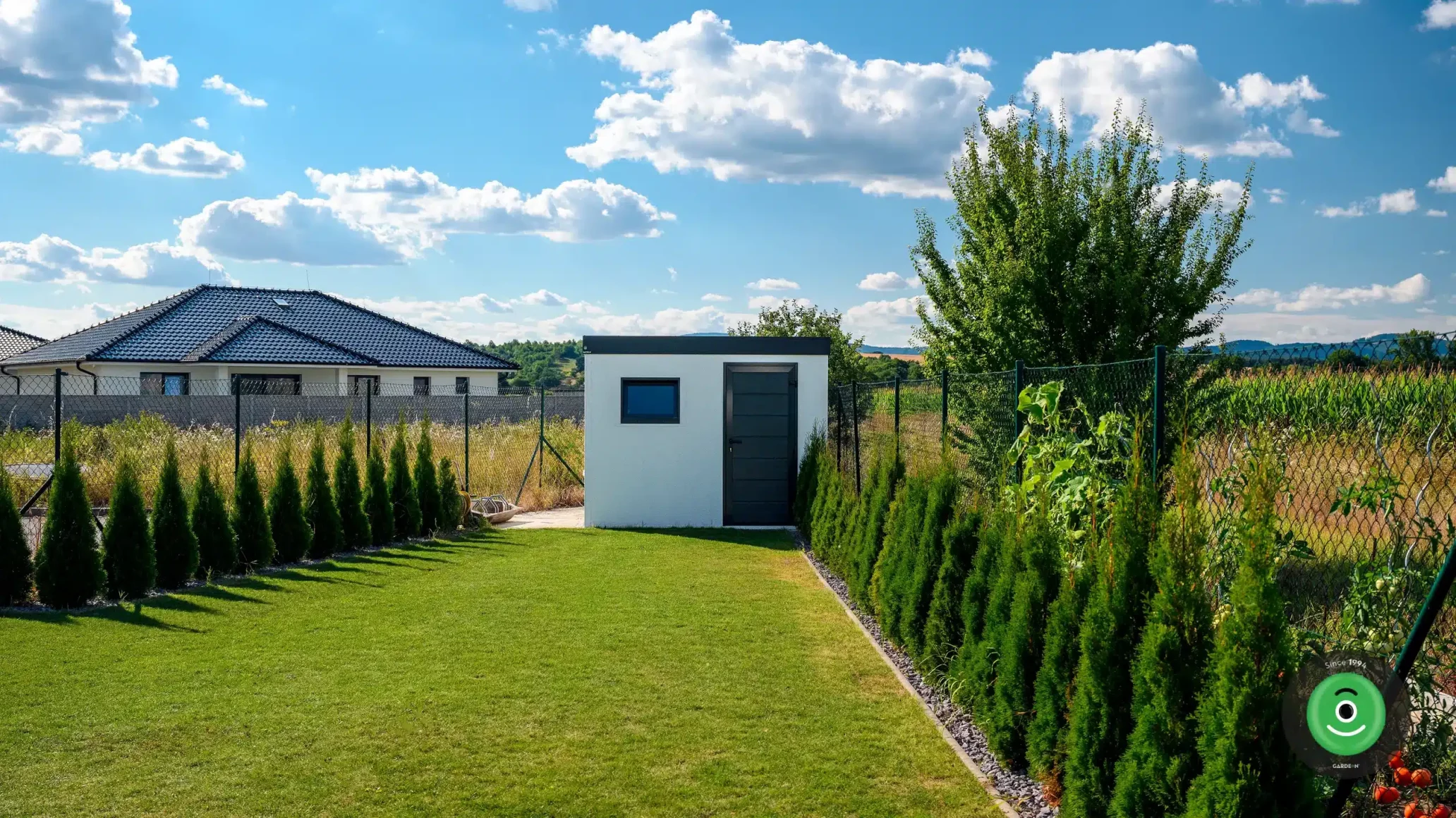 Záhradný domček s pultovou strechou na konci záhrady.