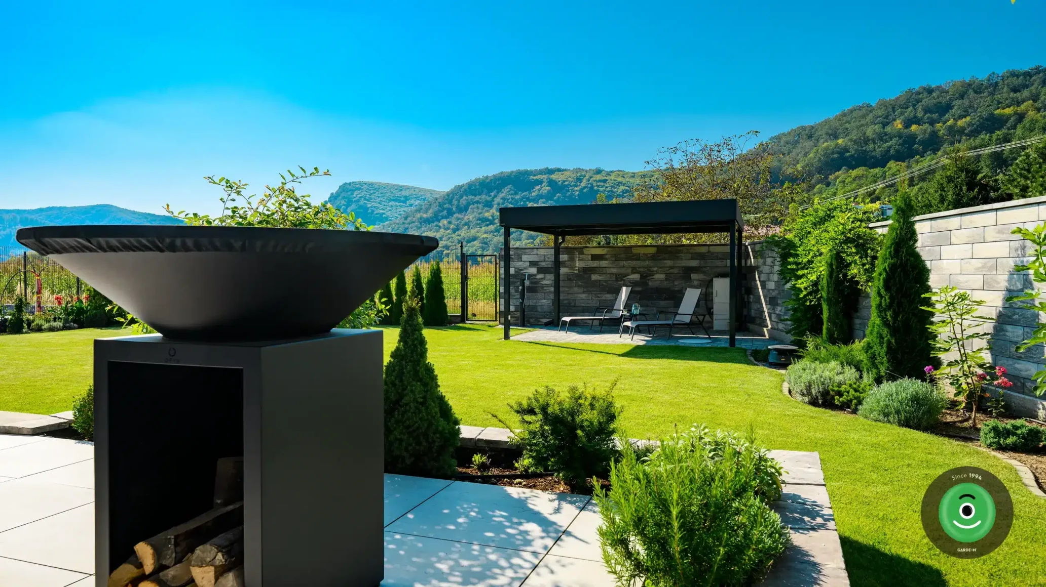 Gardeon pergola s posedením usadená v rohu veľkej záhrady