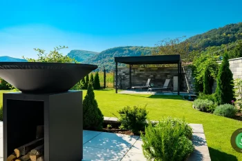 Gardeon pergola s posedením usadená v rohu veľkej záhrady