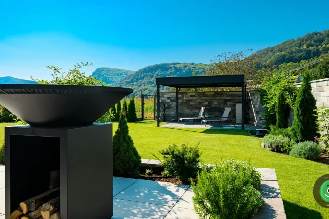 Gardeon pergola s posedením usadená v rohu veľkej záhrady