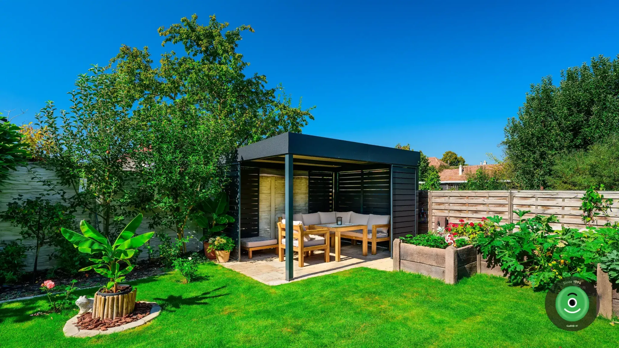 Záhrada obklopená zeleňou a Gardeon pergolou