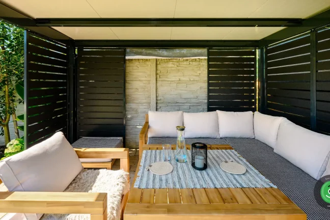 Drevené letné posedenie s vankúšmi v pergole