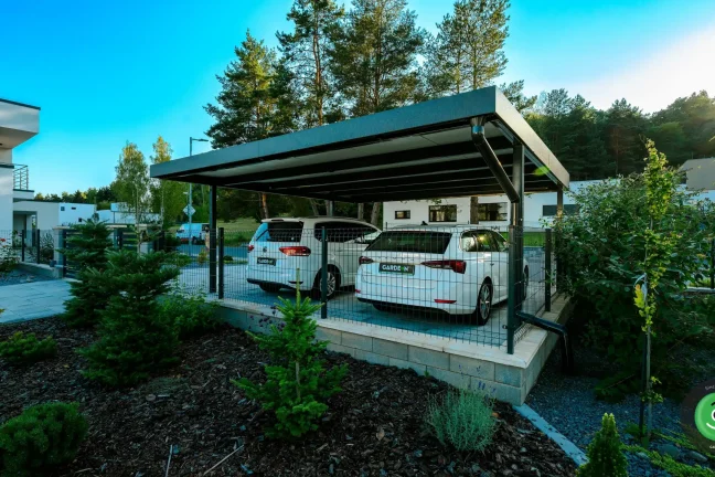 Prístrešok pre dve autá obklopený zasadenými stromčekmi