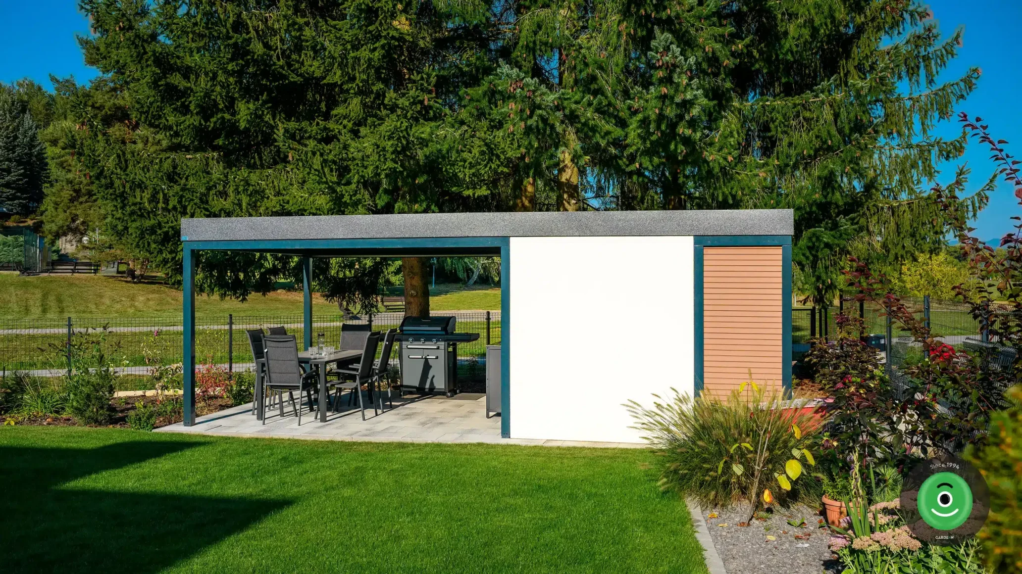 Záhradný domček s prístreškom v okolí kvetovej záhrady