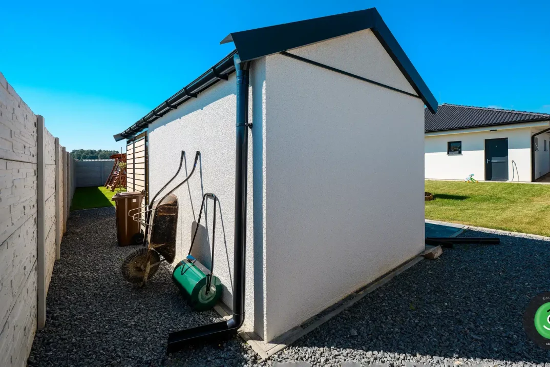 Záhradný domček s fúrikom a valcom na trávnik