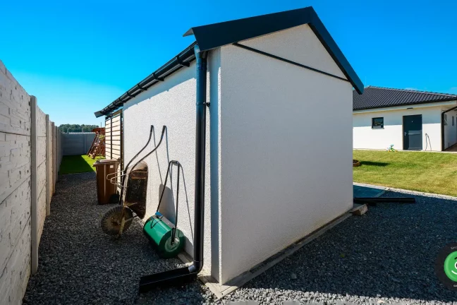 Záhradný domček s fúrikom a valcom na trávnik