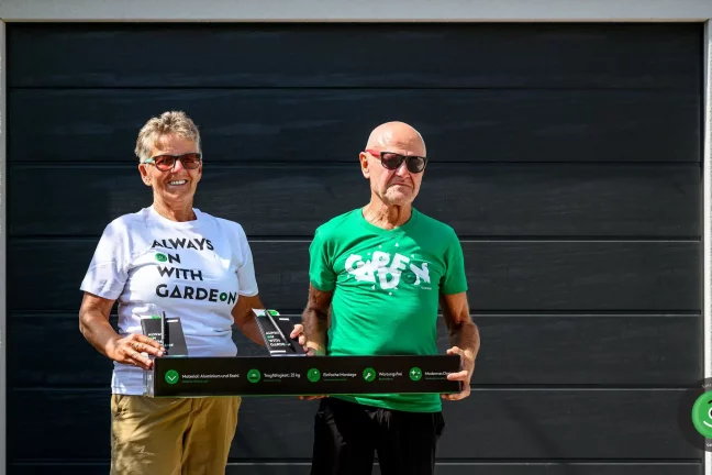 Spokojní zákazníci pred garážou držiaci GARDEON závesný systém