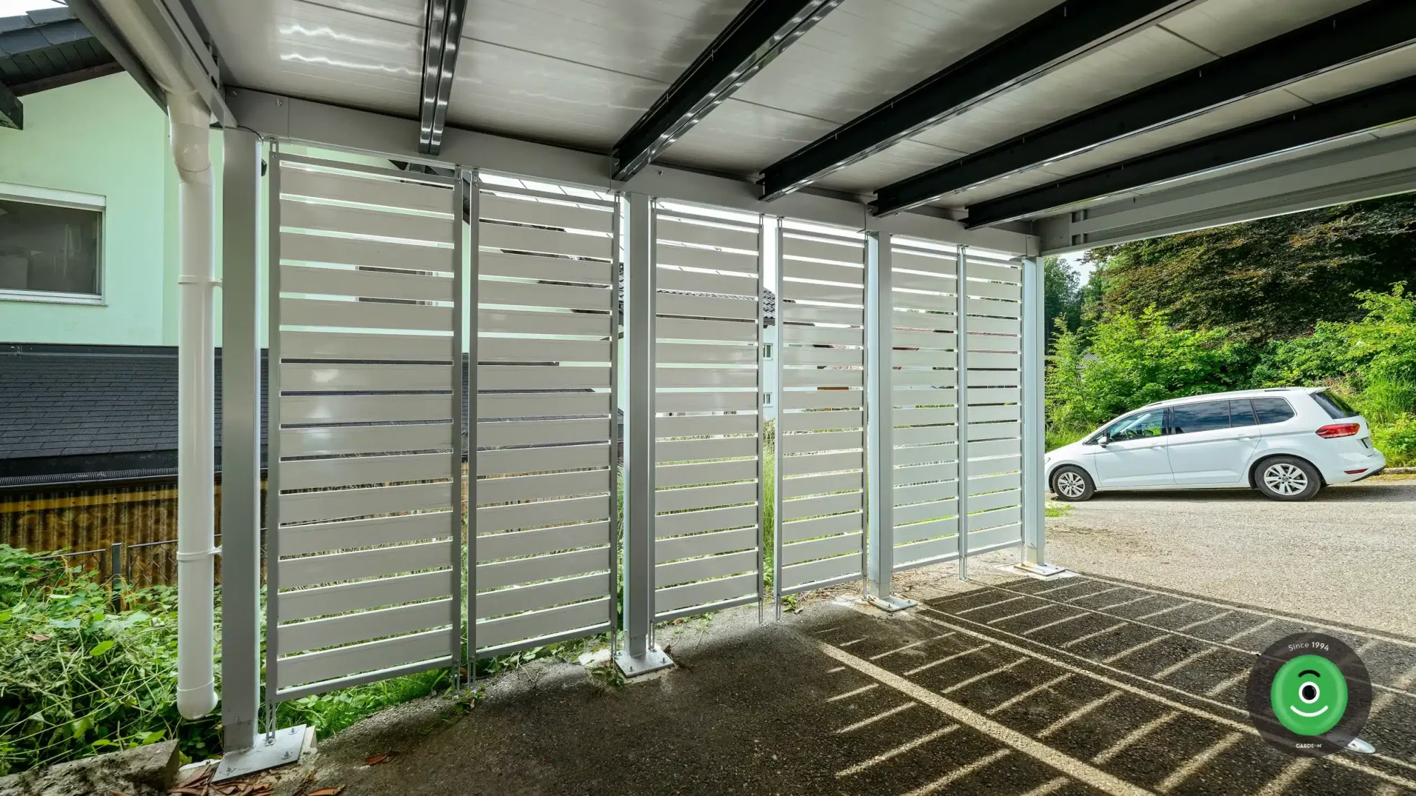 Detail na bielu kovovú výplň v prístrešku pre dve autá