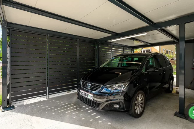 Čierne auto v prístrešku s čiernou kovovou výplňou