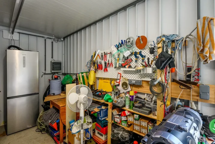 Vnútro záhradného domčeka so závesnými systémami a regálmi