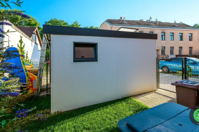 Bočná strana záhradného domčeku s bielou omietkou