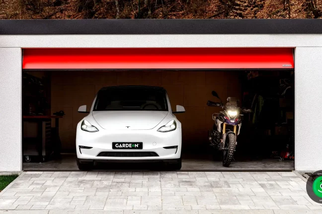 Tesla a motorka v garáži GARDEON s červenou bránou