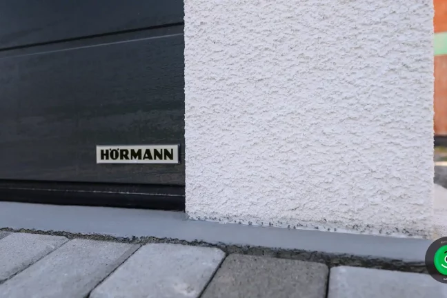 Detail na značku sekcionálnej brány na garáži