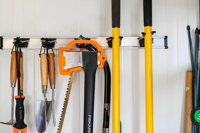 Závesný systém na náradie nainštalovaný na stene záhradného domčeka
