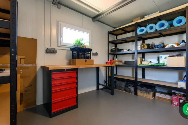 Vnútro gardeon záhradného domčeka s regálmi ako úložný priestor