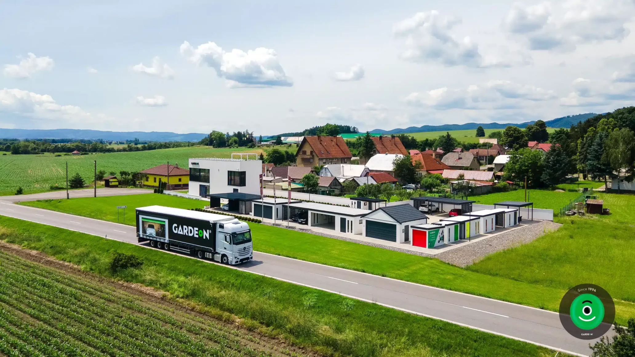 Kamión na ceste s nápisom GARDEON a zobrazenou fotografiou garáže