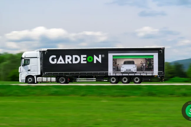 Fotografia Tesly v garáži zobrazená na bočnej stene kamiónu