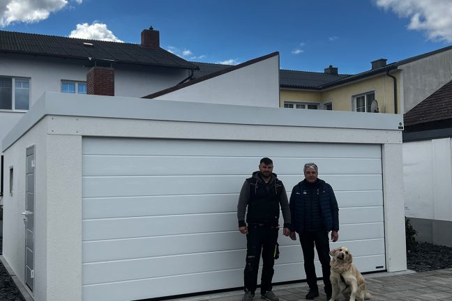 spokojný zákazník so psíkom pred bielou garážou