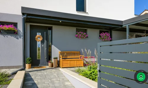 Malý prístrešok pred dverami s drevenou lavičkou na sedenie