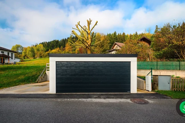 veľká garáž s čiernou širokou bránou
