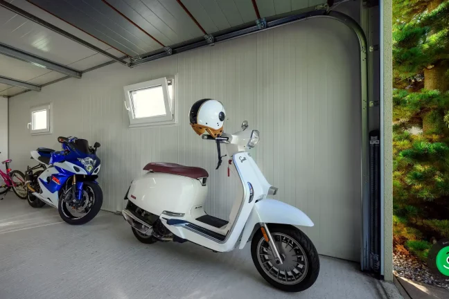 skúter, motorka a bicykel uložené vo vnútri garáže
