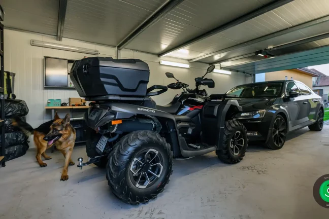 štvorkolka a auto zaparkované vo vnútri garáže