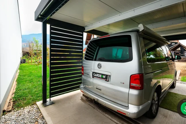 auto pod prístreškom s čiernou kovovou výplňou