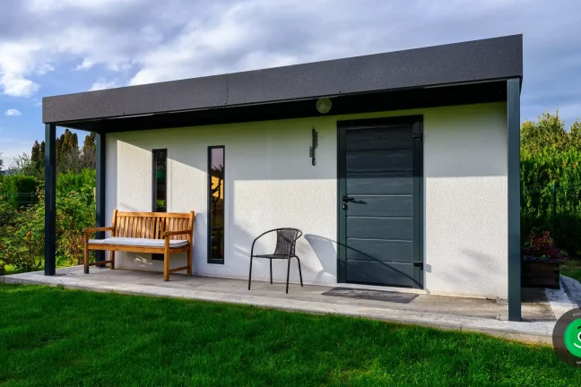 drevená lavička pod prístreškom pred záhradným domčekom