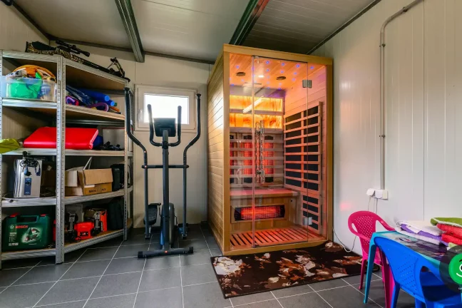 sauna s posilňovacími strojmi vo vnútri záhradného domčeka