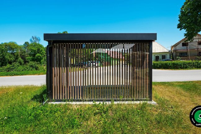 Prístrešok vo forme zástavky umiestnený pri chodníku.