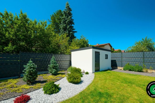 Domček v bielej farbe v záhrade.