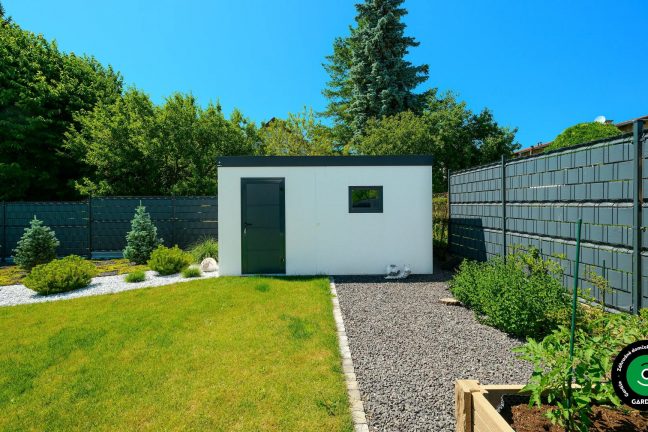 Biela stavba, ktorá ladí s upraveným trávnikom.