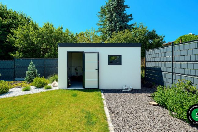 Kompaktný biely domček uprostred rozkvitnutej záhrady.