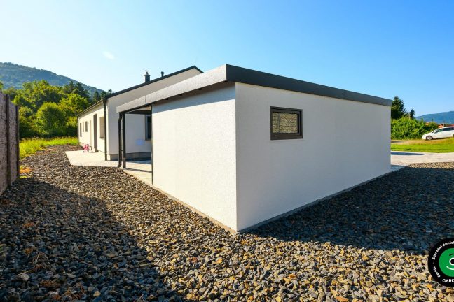 Jednoduchá garáž s moderným prístreškom využívaným ako terasa.