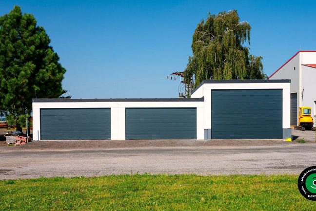 Garážová stavba s viacerými veľkými vstupmi na stroje a autá.