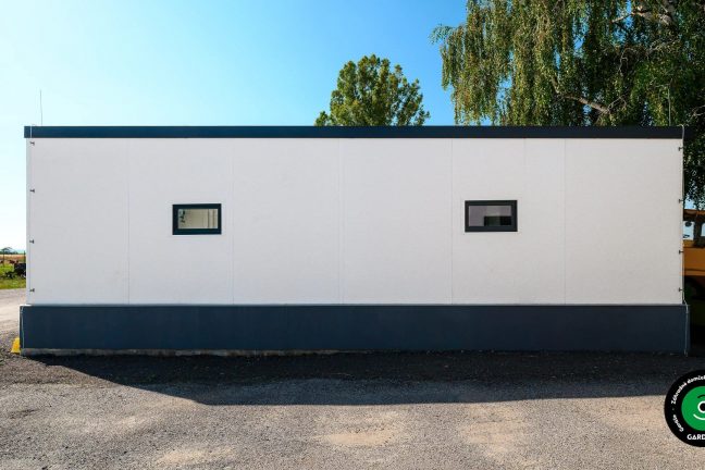 Otvorená garážová stavba prispôsobená na stroje a stavebné mechanizmy.