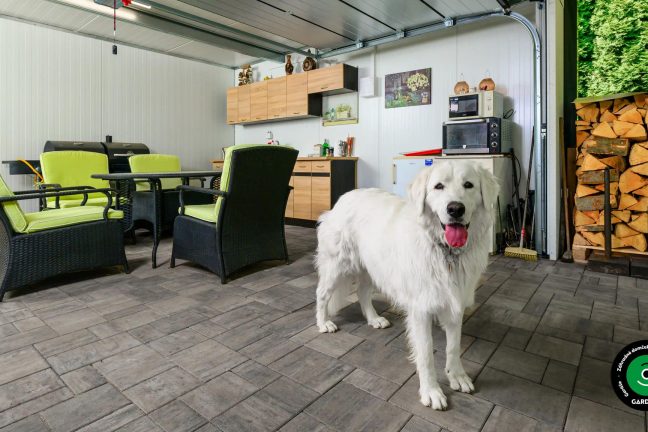 Záhradný domček s modernou garážovou bránou a kuchynkou.