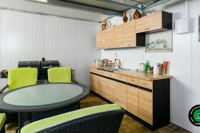 Letná kuchynka ukrytá vo vnútri záhradného domčeka.