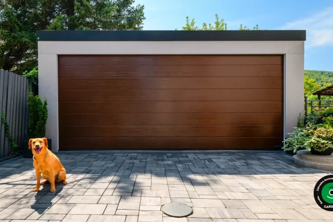Pes sedí pred elegantnou dvojgarážou s dreveným vzhľadom.