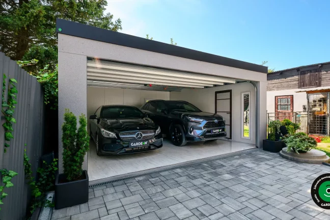 Dvojgaráž s otvorenou bránou a dvomi vozidlami.