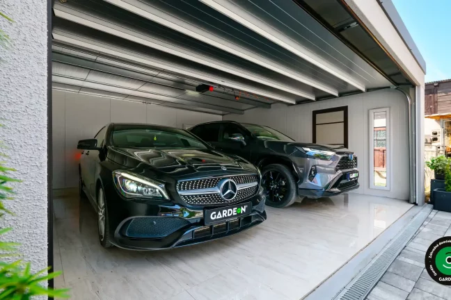 Interiér garáže s dvomi autami a svetlou podlahou.