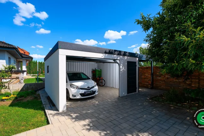 Moderná montovaná garáž s pultovou strechou a parkovaným bielym autom Toyota.