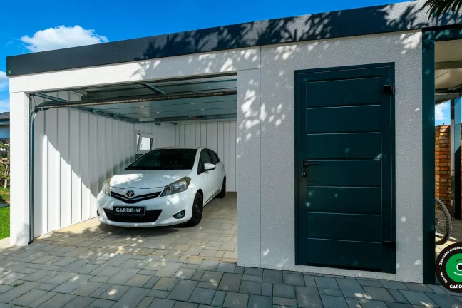 Montovaná garáž s otvorenou sekčnou bránou a bočnými dverami v antracitovej farbe.