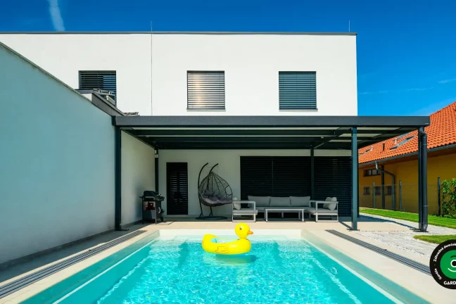 Moderná pergola pri bazéne s nafukovacou kačkou.