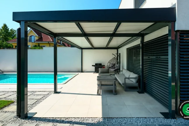 Minimalistická pergola so sedením a grilom pri dome.