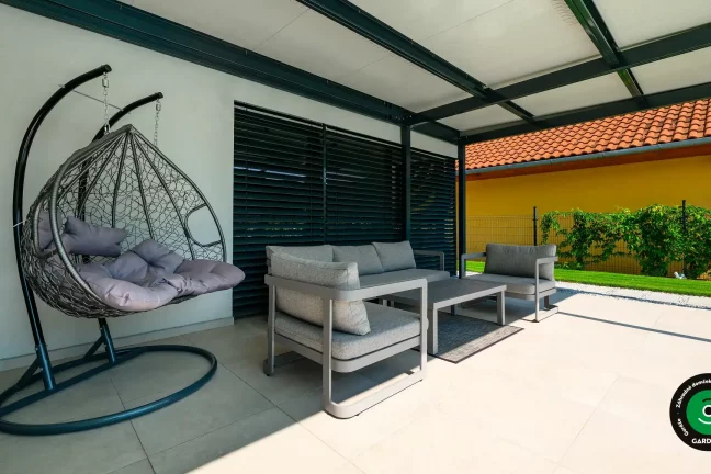 Zastrešené sedenie s hojdacím kreslom a pohovkou.