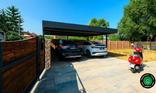 Moderný prístrešok pre dve autá s tmavou strechou a vydláždeným dvorom.