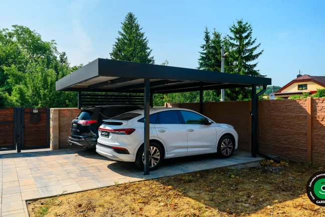 Bočný pohľad na moderný prístrešok s bielym a čiernym autom.